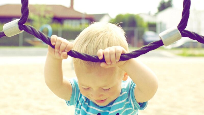 child playing on playground ropes