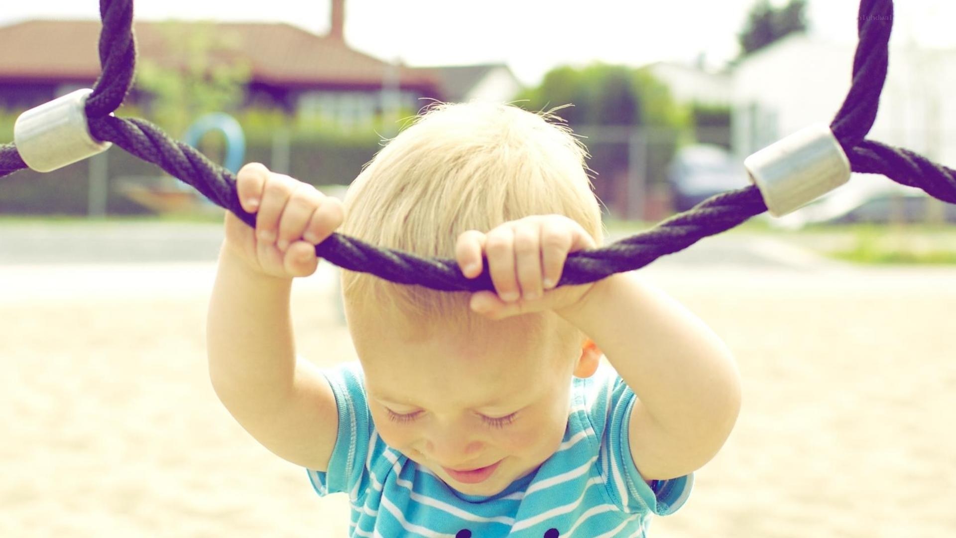 child playing on playground ropes