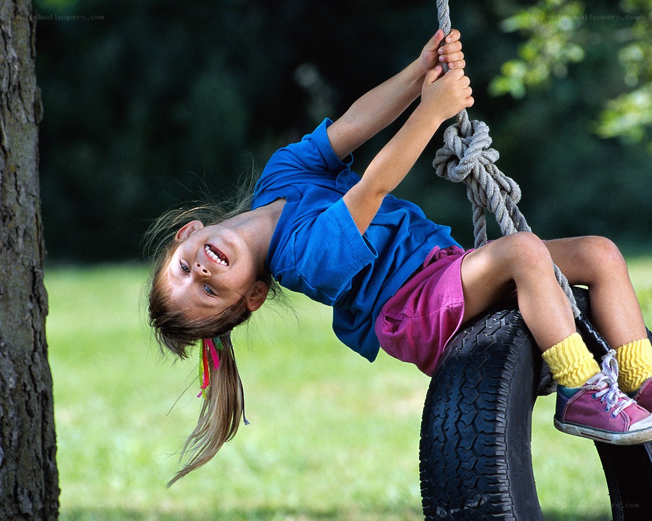 child playing on tire swing
