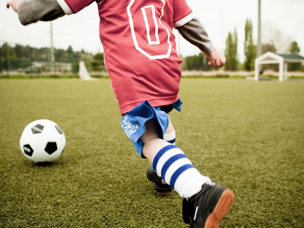 child playing soccer on field