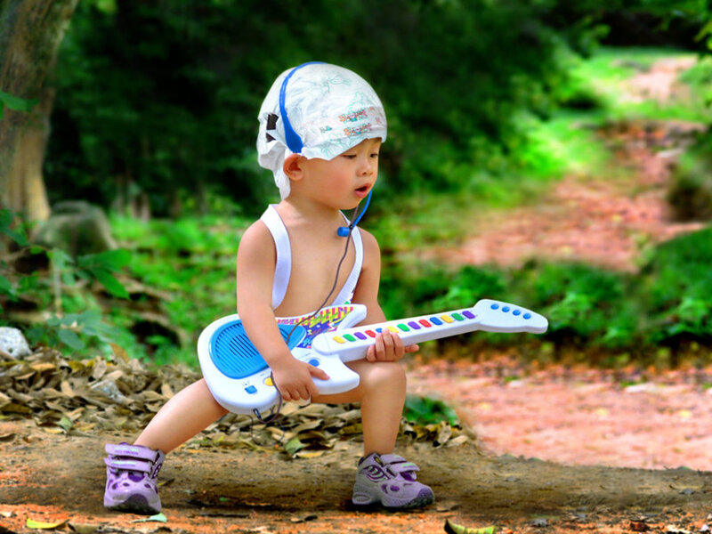 child playing toy guitar outdoors