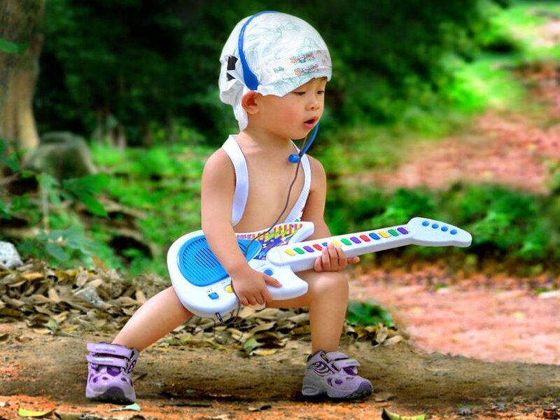 child playing toy guitar outdoors