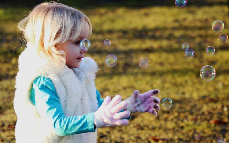child playing with bubbles
