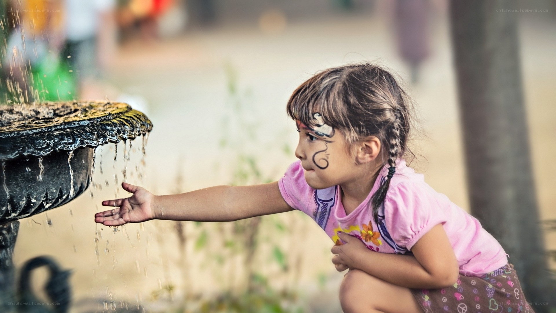 child playing with fountain water