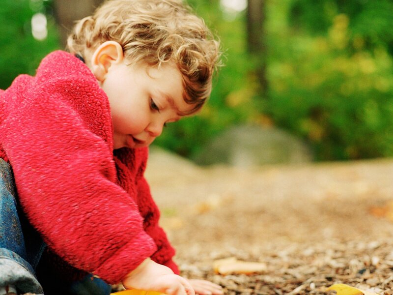 child playing with leaves