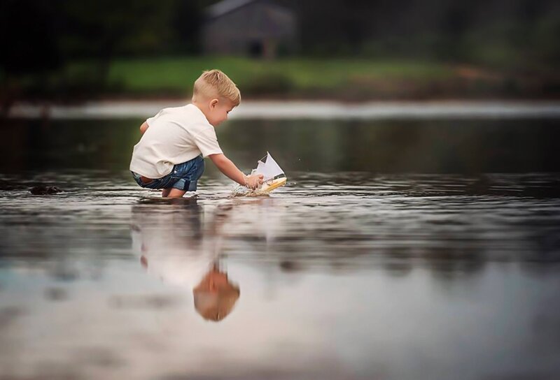 Child Playing with Toy Boat — Brown