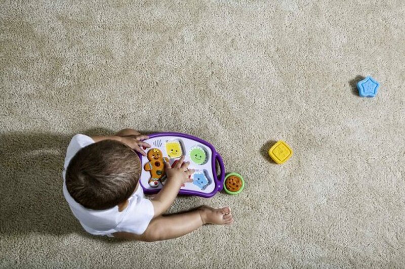 child playing with toy on carpet