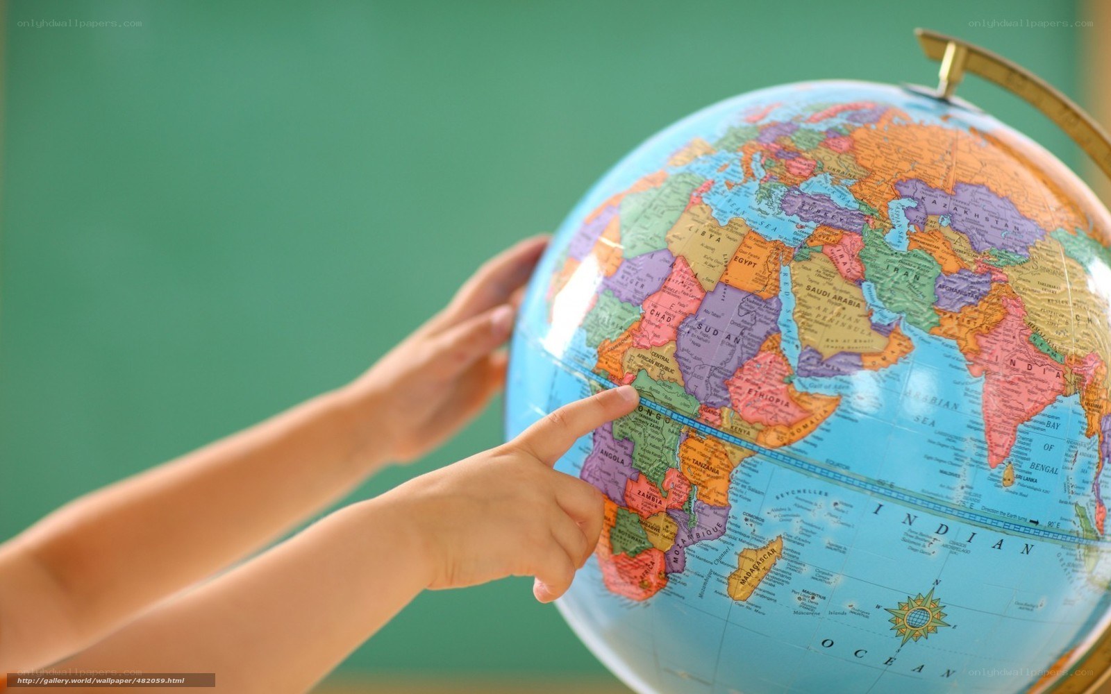 child pointing at globe