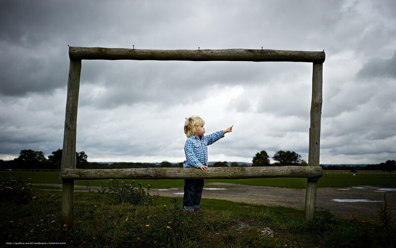 Child pointing through wooden frame