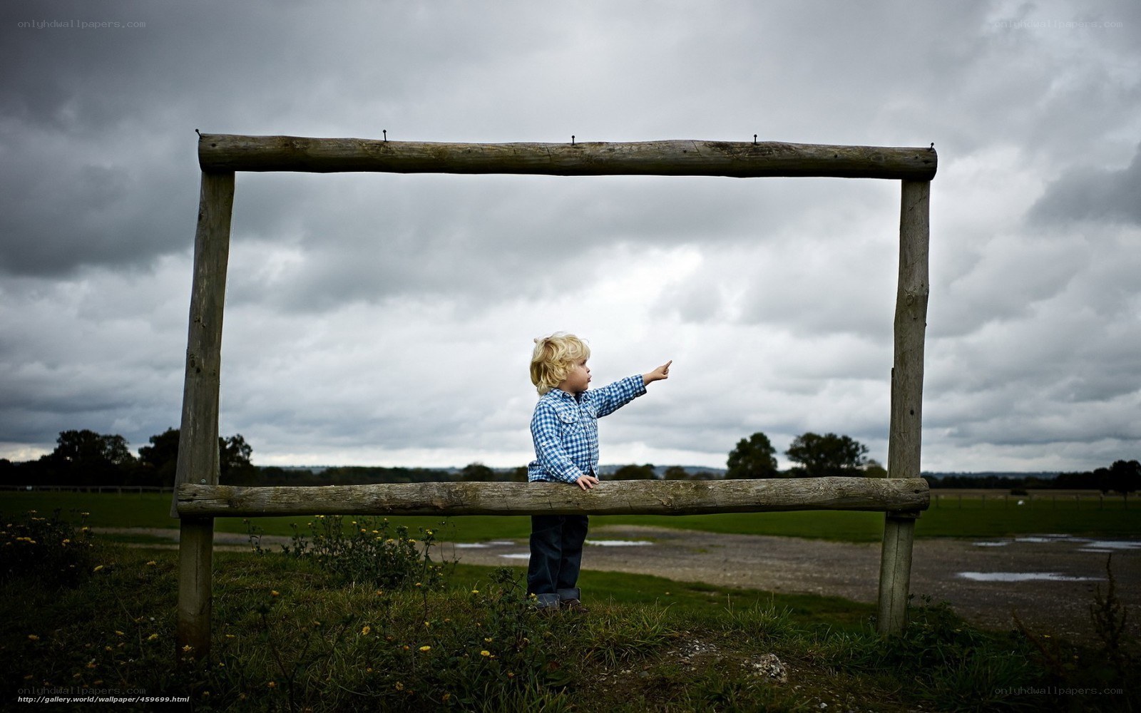 Child pointing through wooden frame