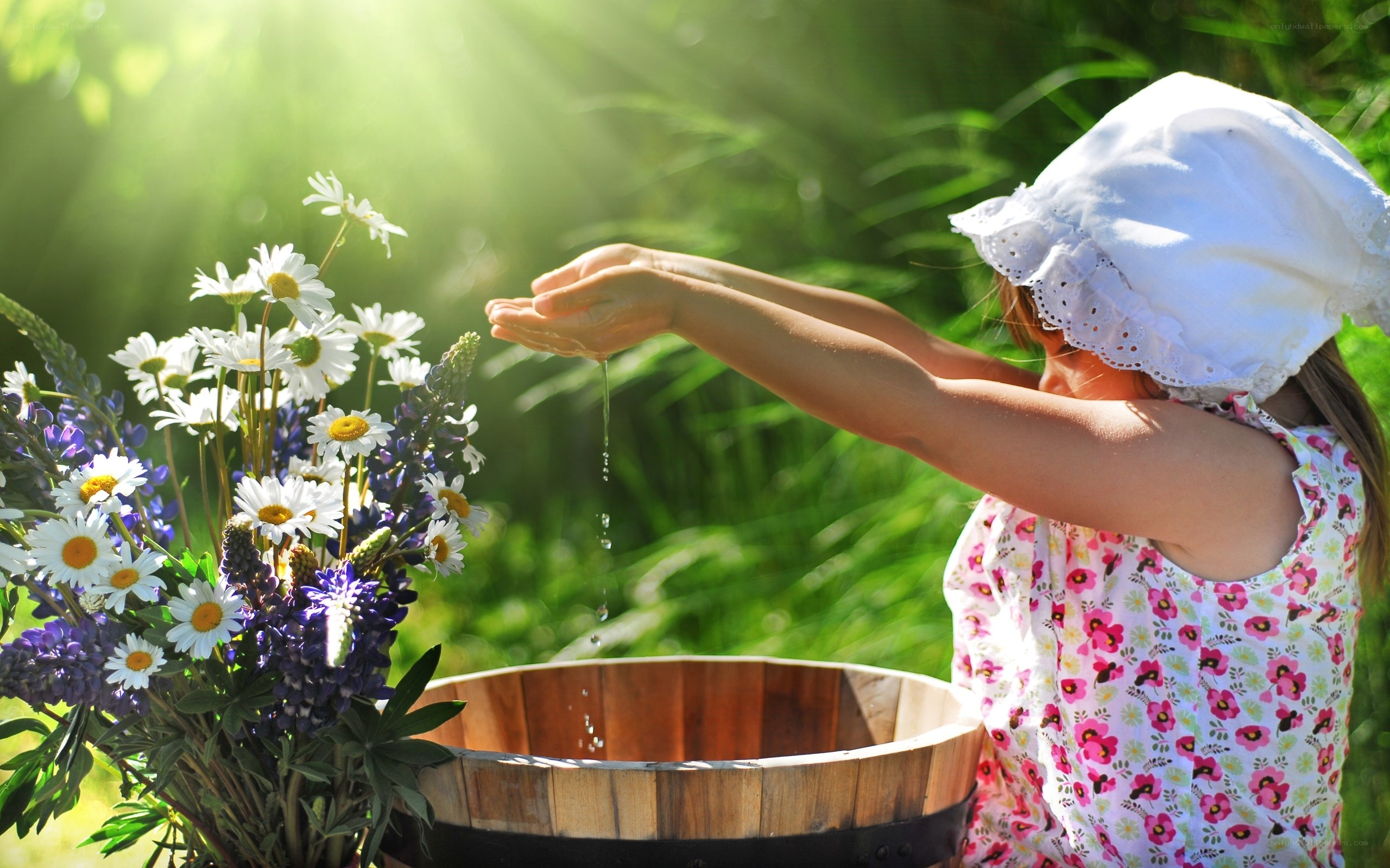 child pouring water on flowers
