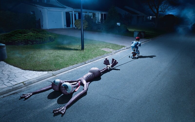 Child pulling alien on bike
