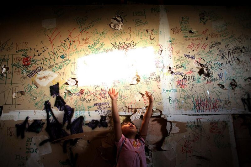Child Reaching Up to Light