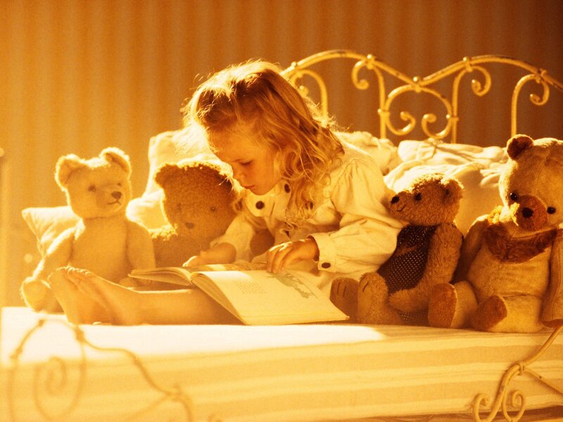 child reading with teddy bears