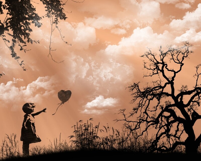 child releasing heart balloon