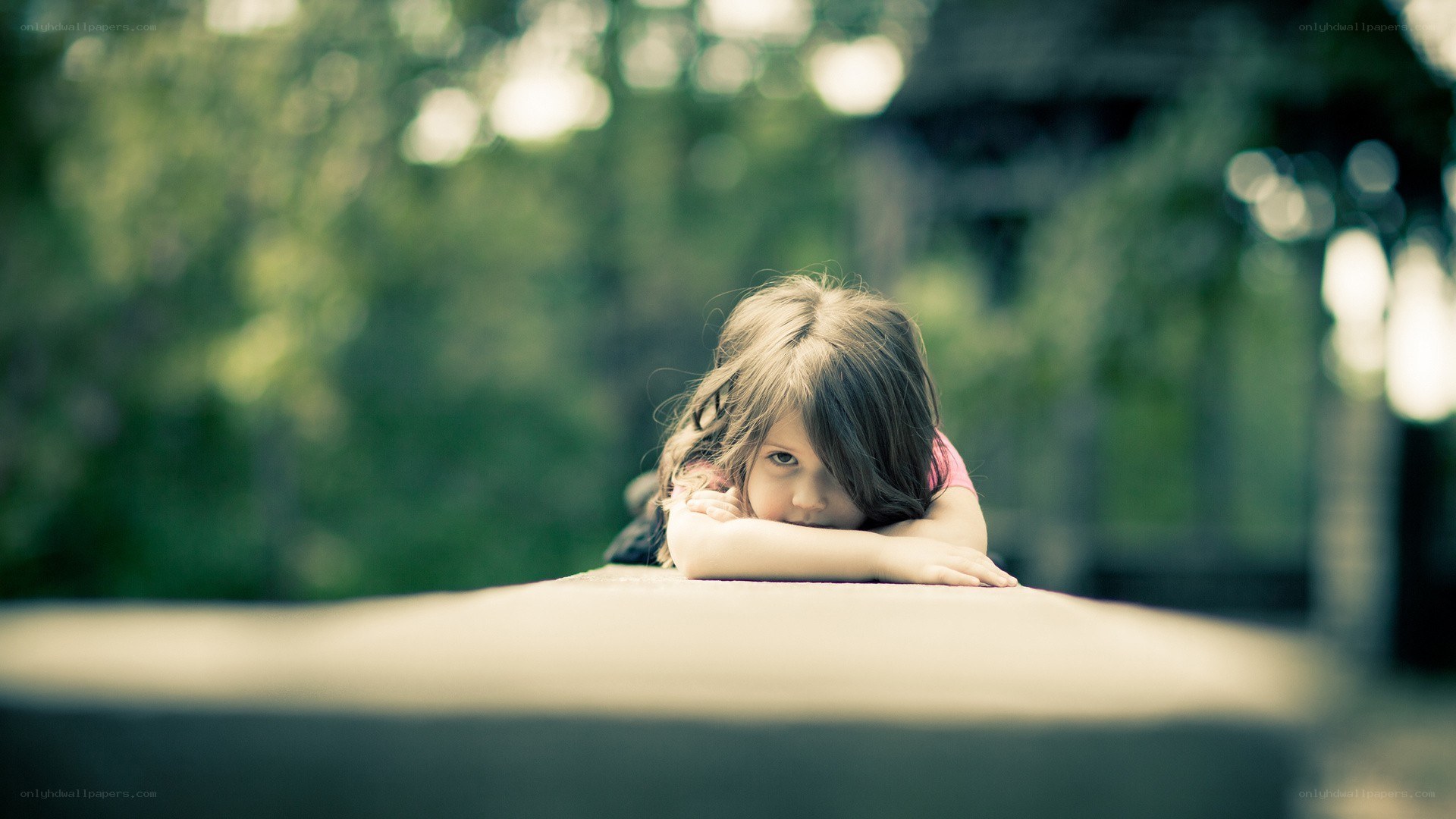 child resting on a wall