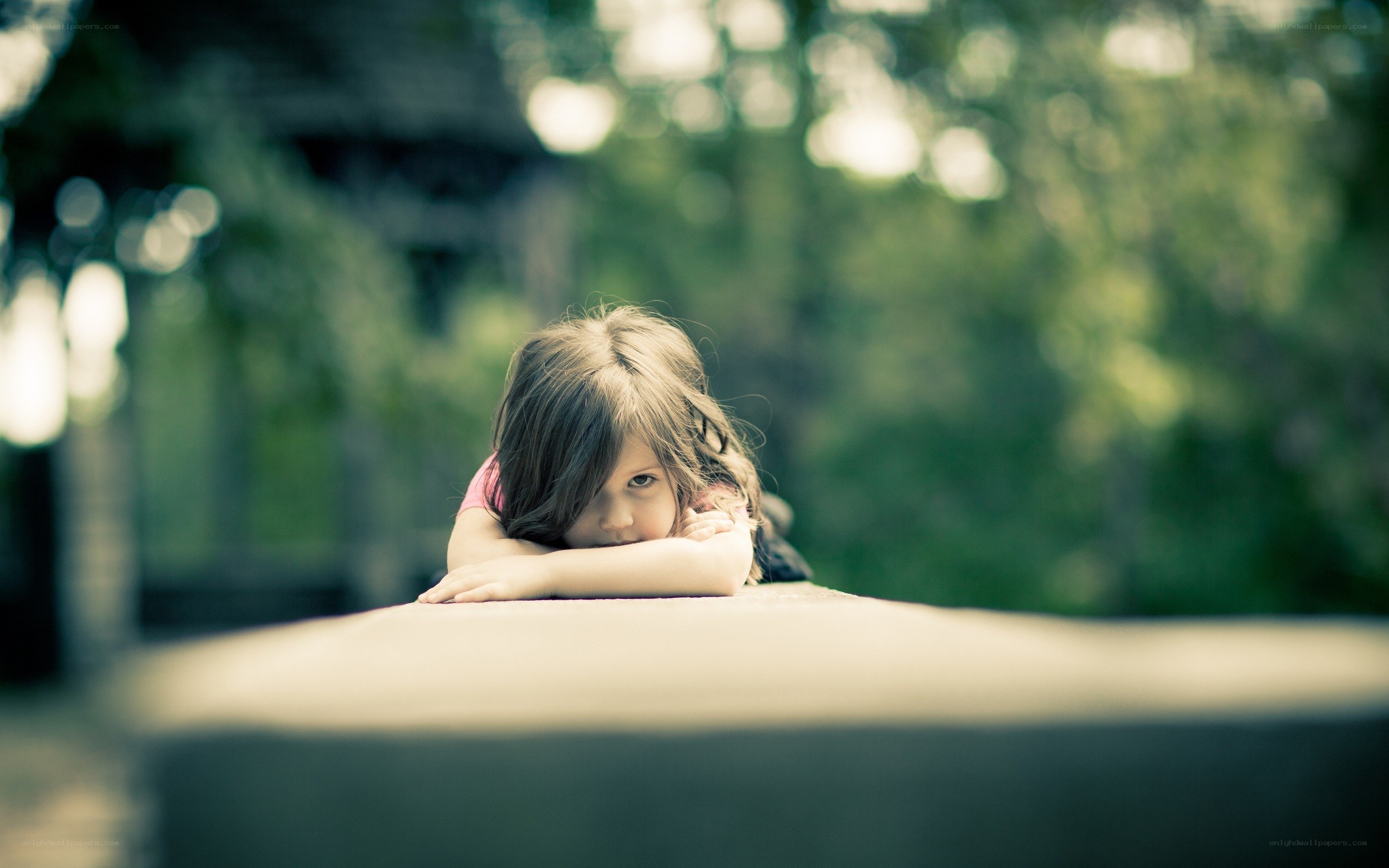 child resting on a wall
