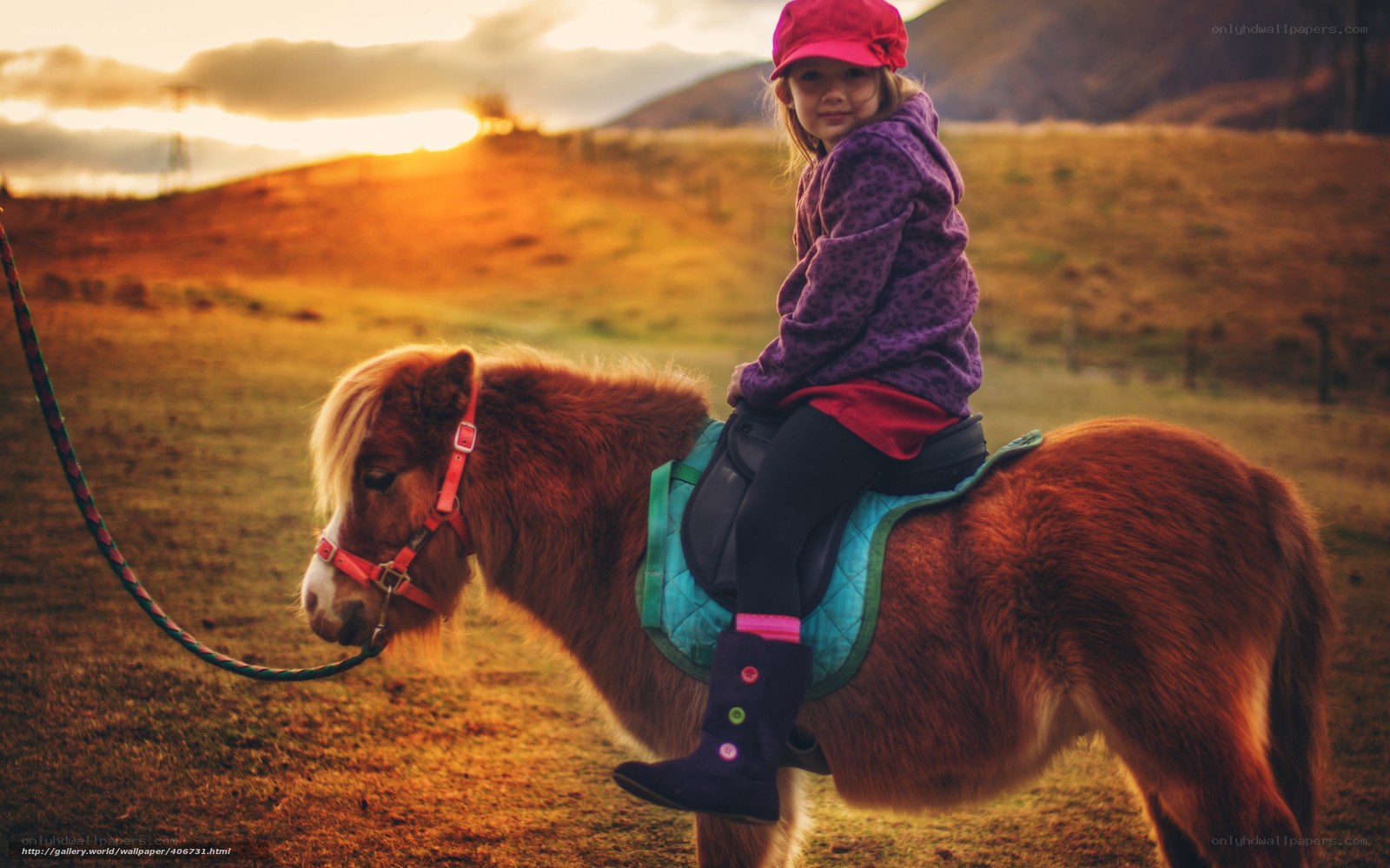 child riding a pony at sunset