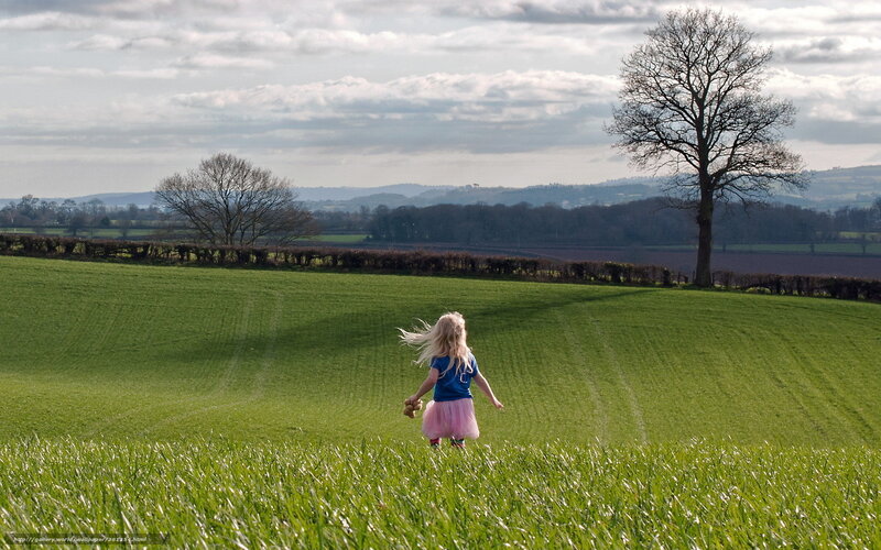 Child running in a green field