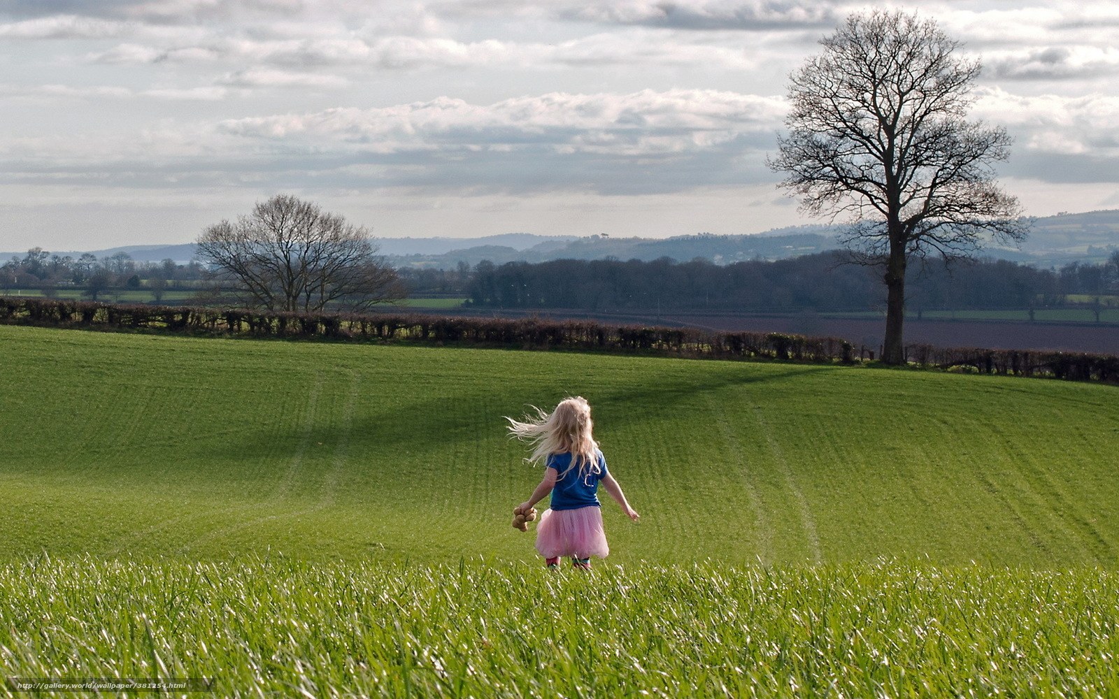 Child running in a green field