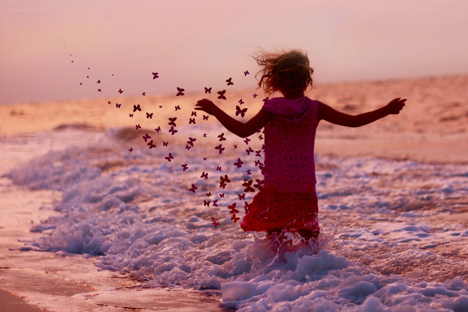 Child running on beach at sunset