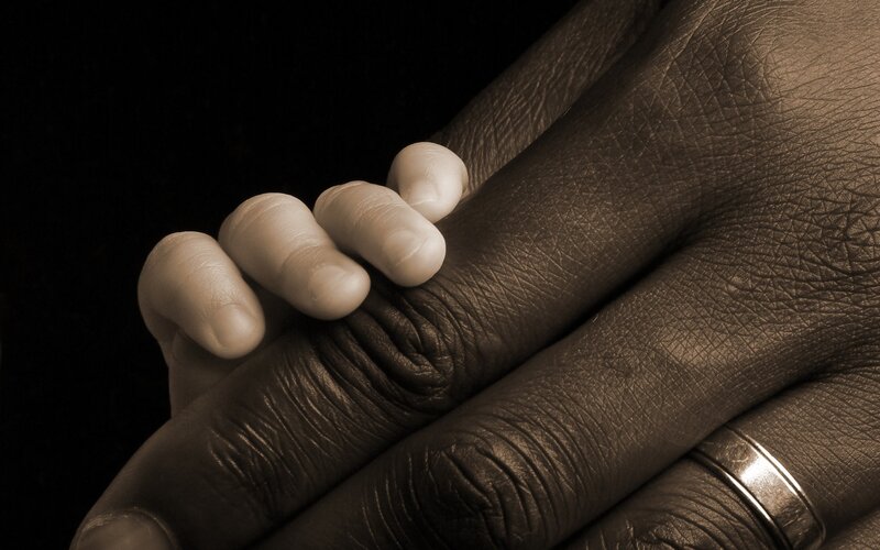 child's hand holding adult hand