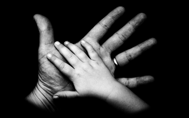 Child's Hand on Adult Hand — Black