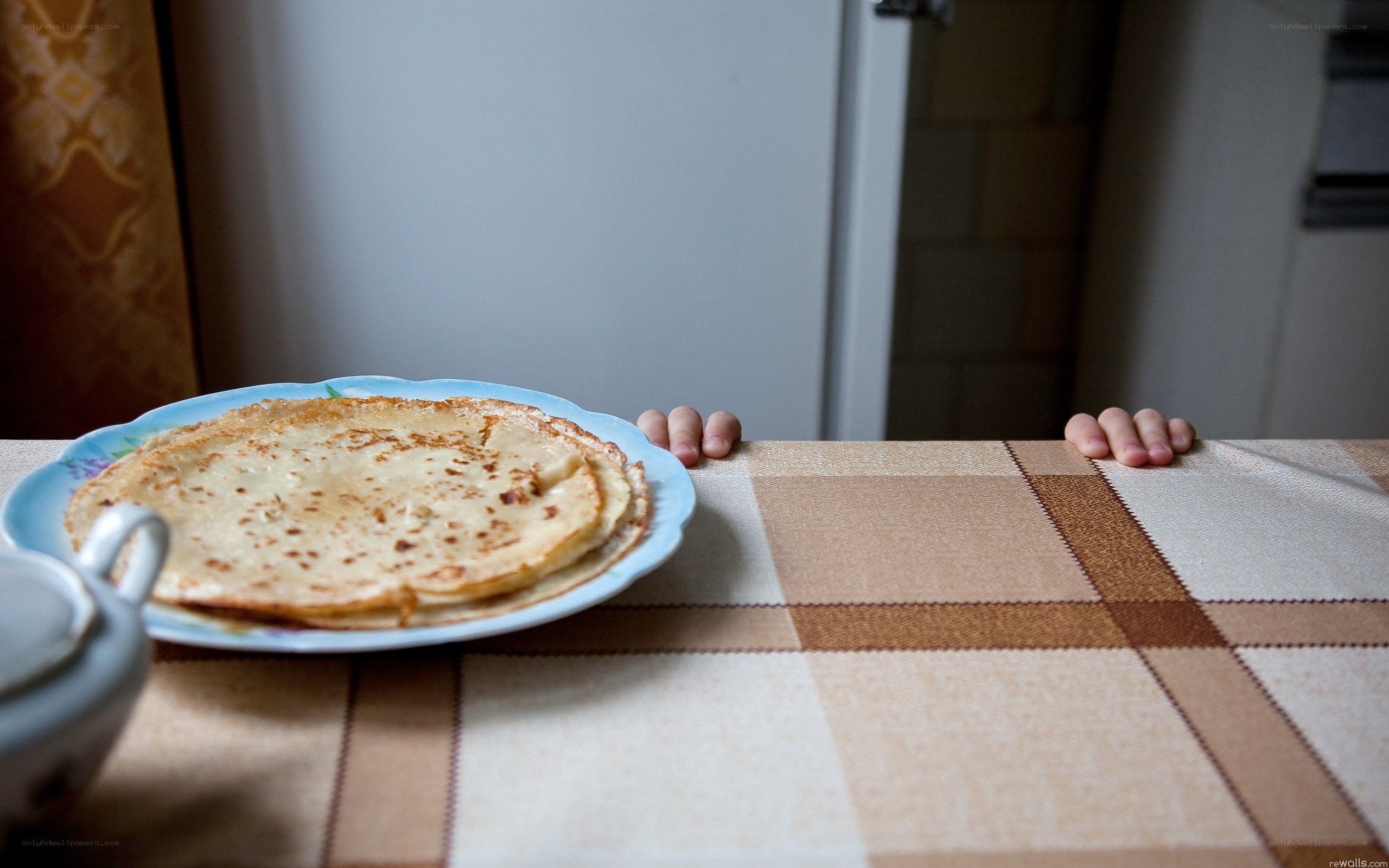 Child's hands on table with pancakes