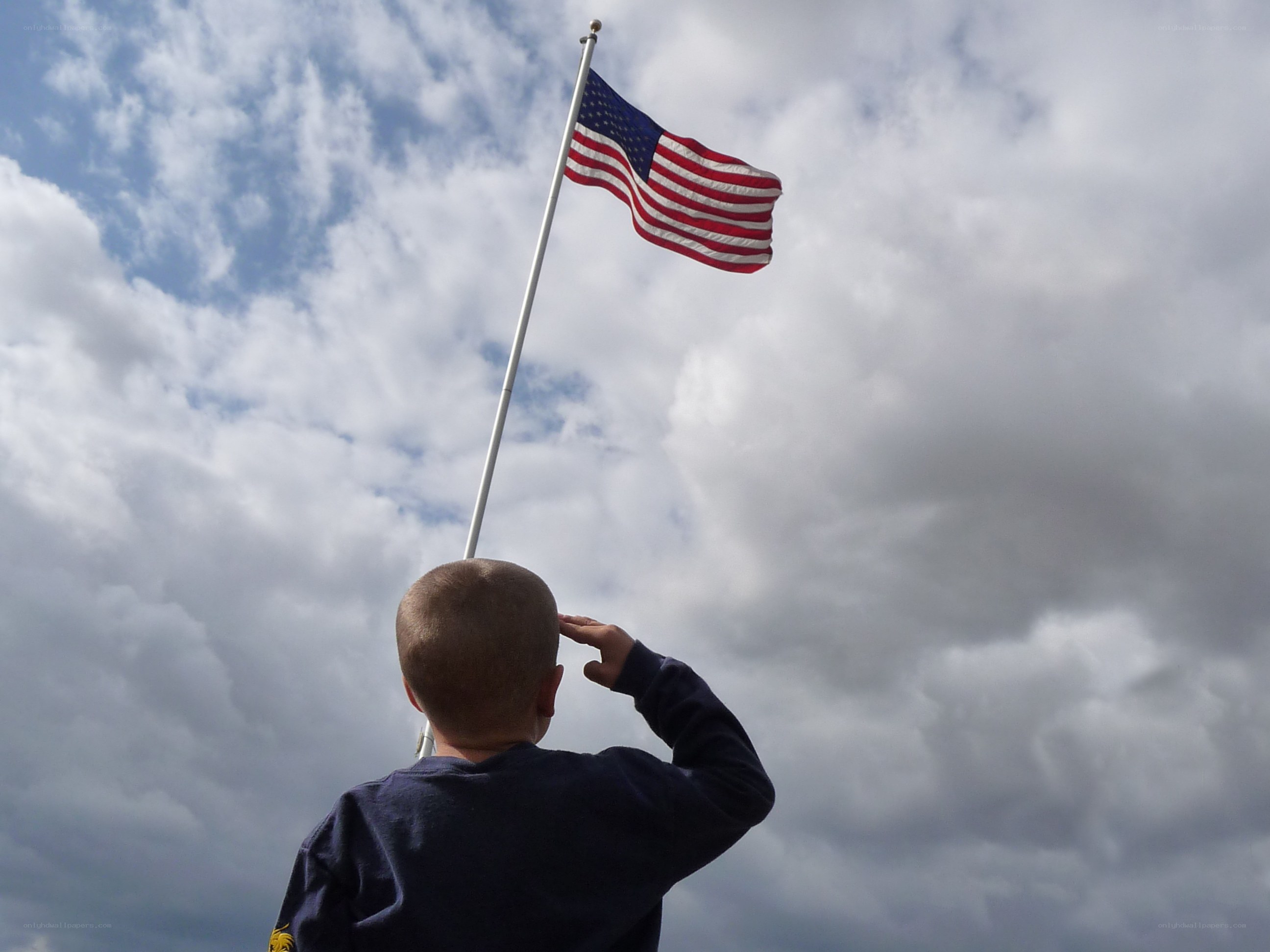 child saluting american flag