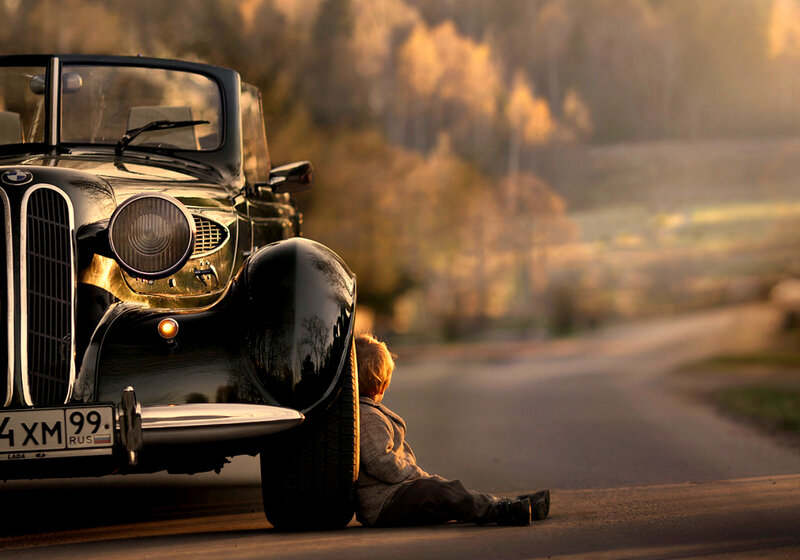 Child Sitting by Car
