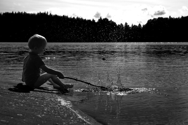 Child Sitting by Lake