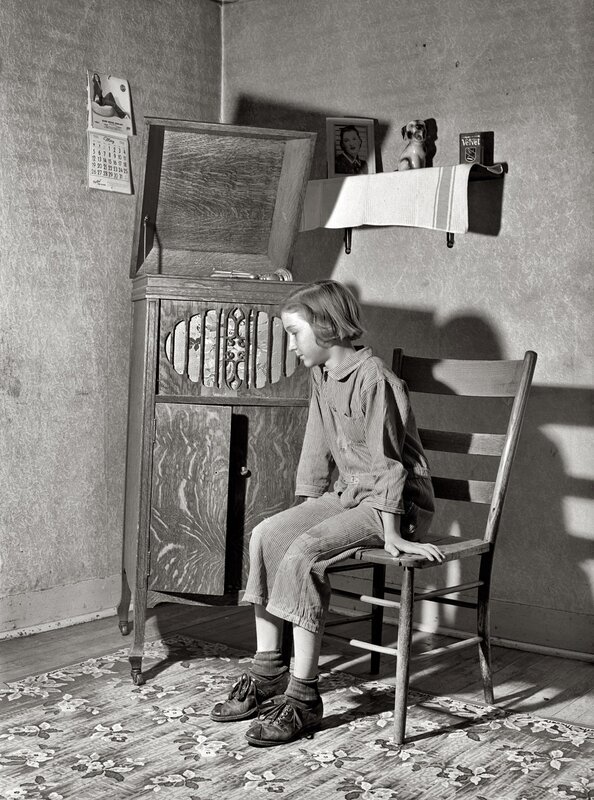 child sitting by phonograph