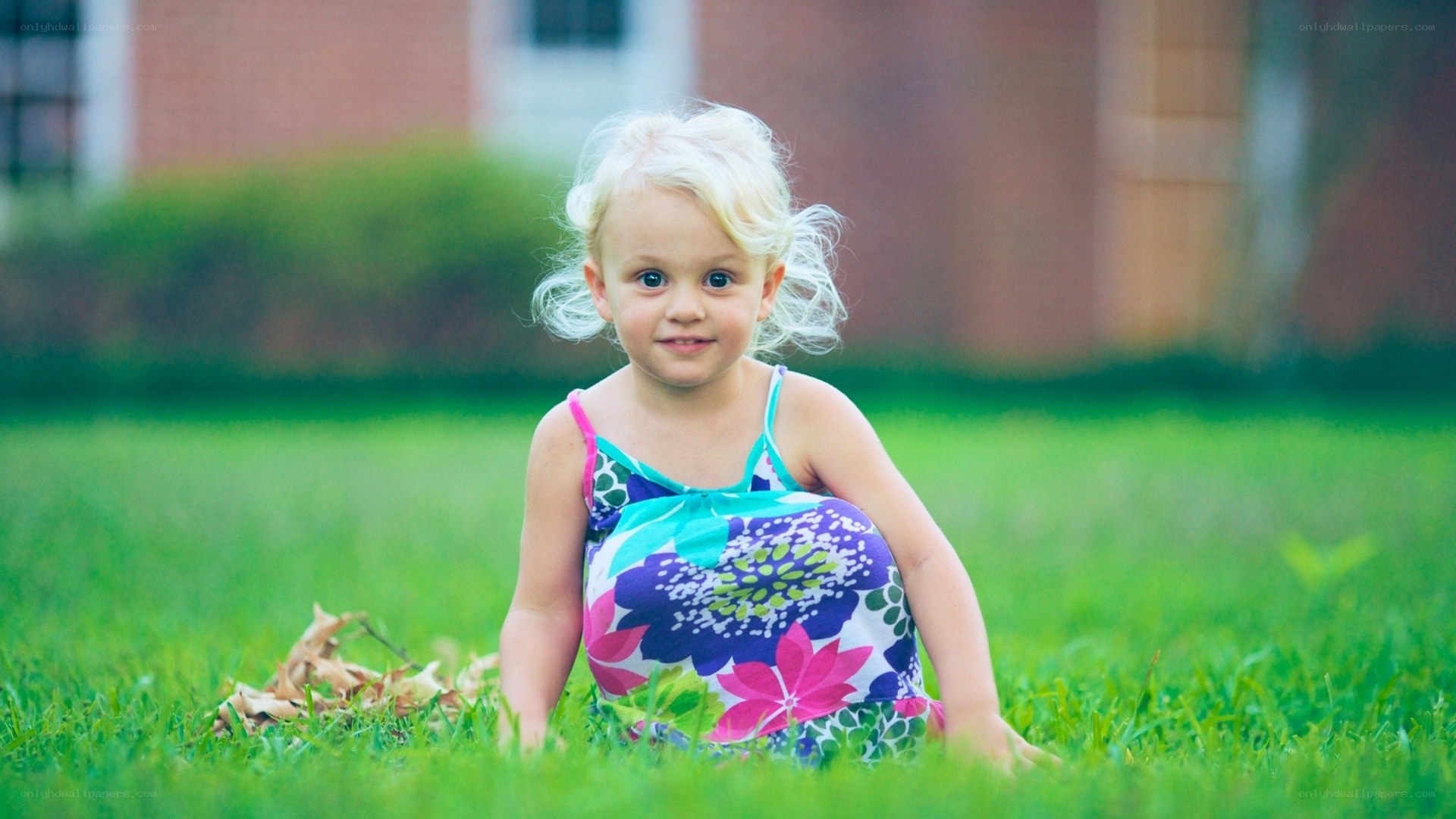 child sitting in grass
