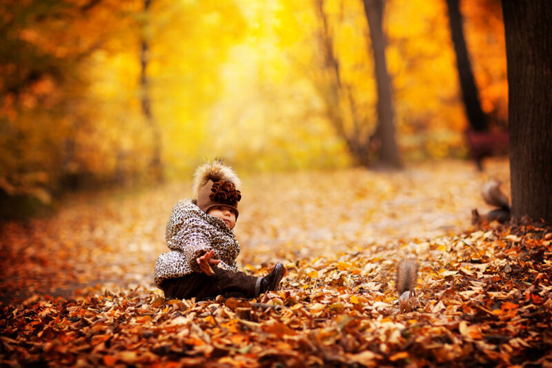 Child Sitting in Leaves — Yellow