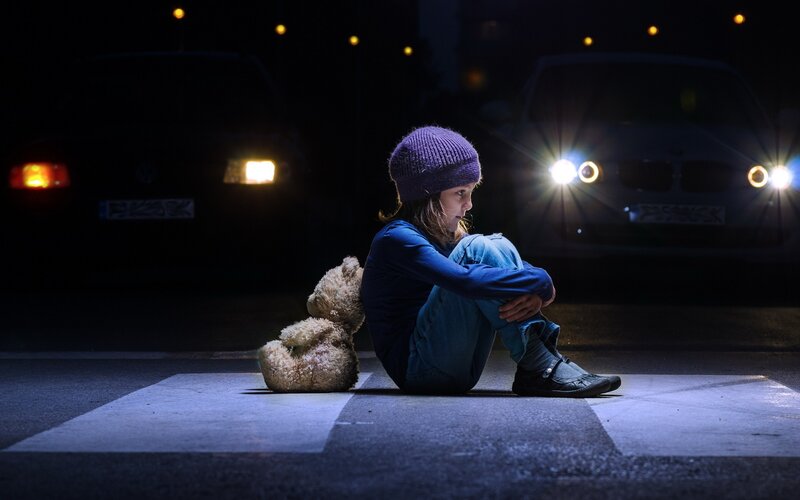 Child Sitting on Crosswalk
