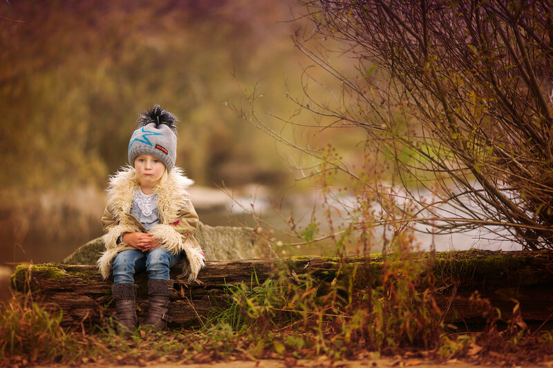 Child Sitting on Log — Brown
