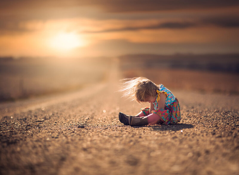 Child Sitting on Road — Brown