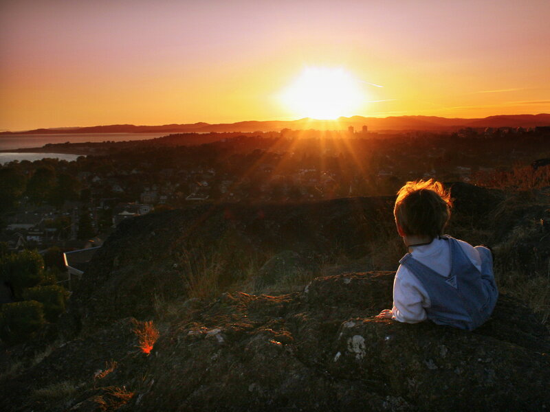 Child Sitting on Rock — Orange