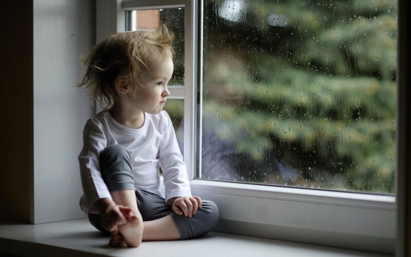 Child Sitting on Windowsill