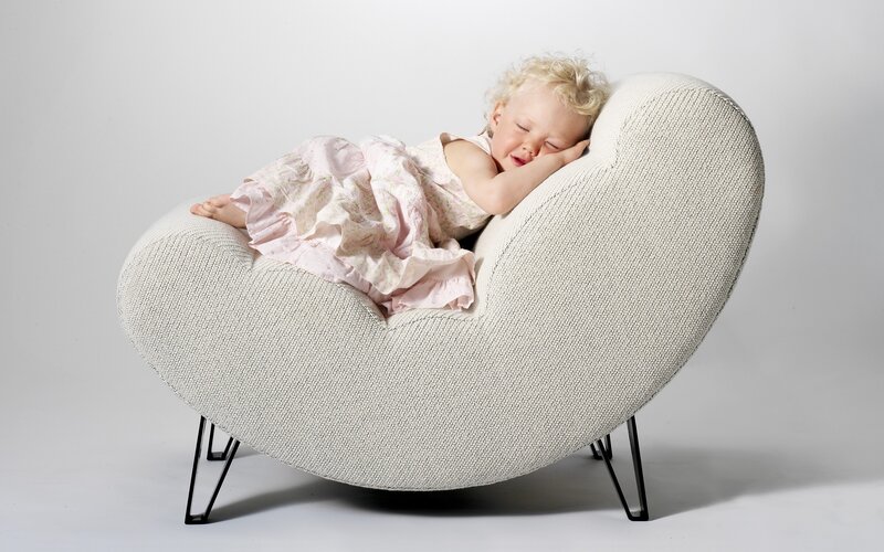 child sleeping in heart-shaped chair