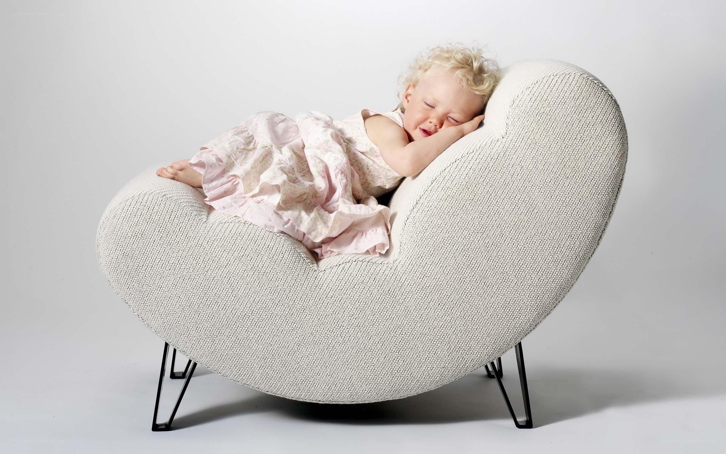 child sleeping in heart-shaped chair