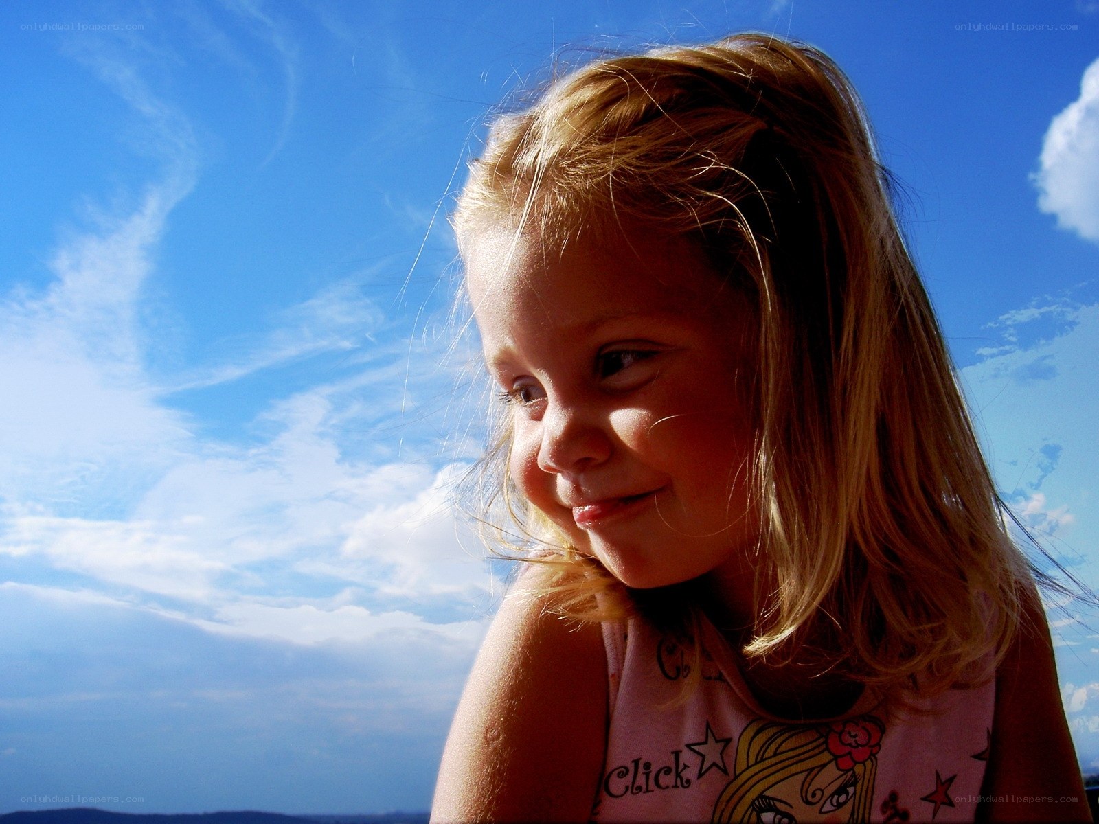 child smiling against blue sky