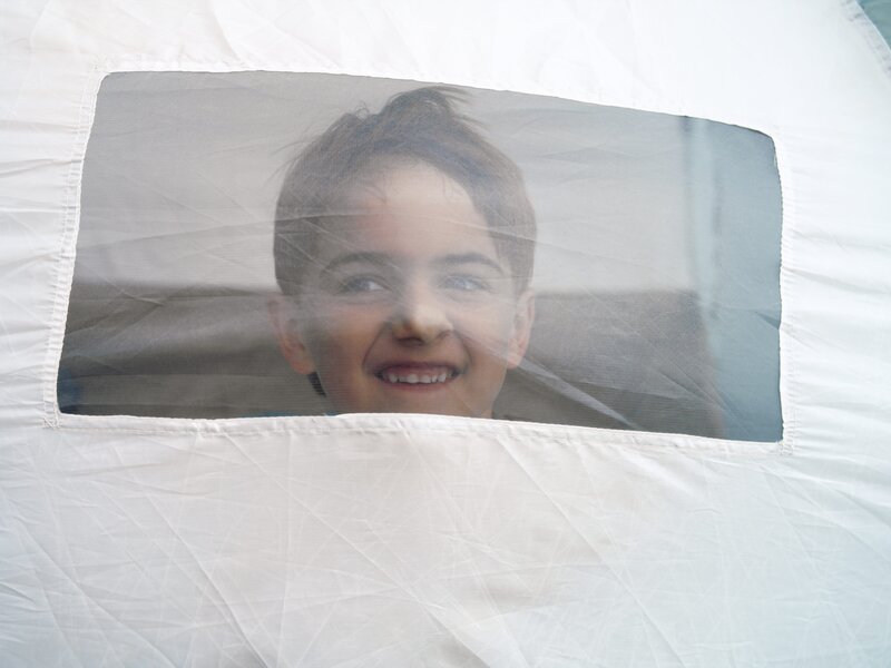 child smiling through tent window