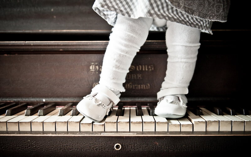 Child Standing on Piano Keys — Black