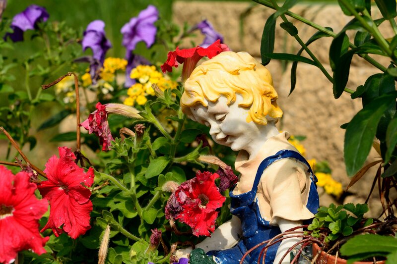 Child Statue in Garden — Red