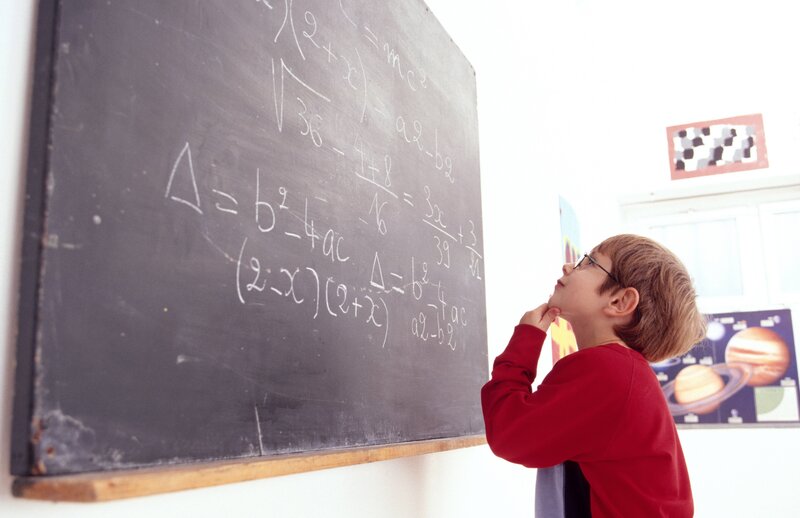 Child studying math on chalkboard