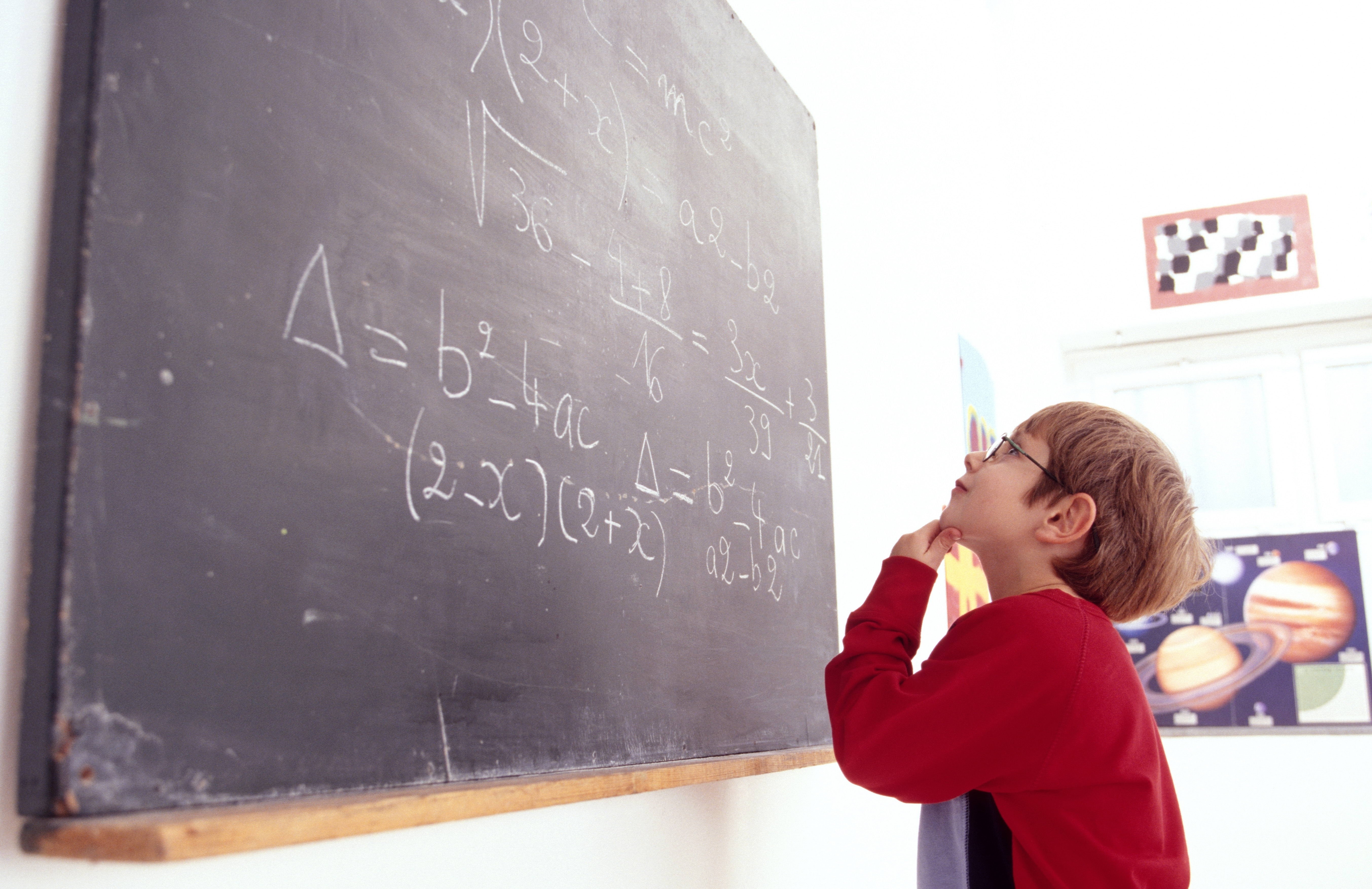 Child studying math on chalkboard