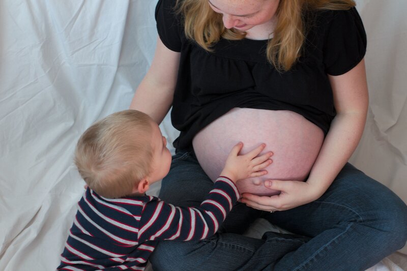 child touching mother's pregnant belly
