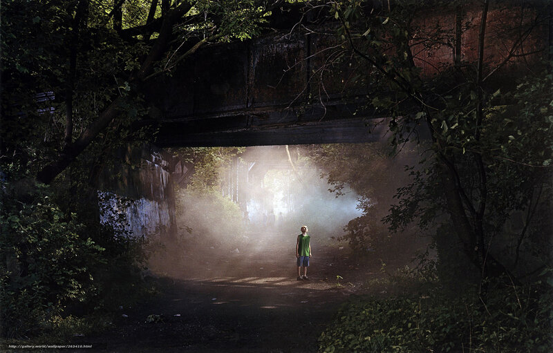 Child under a bridge at dusk