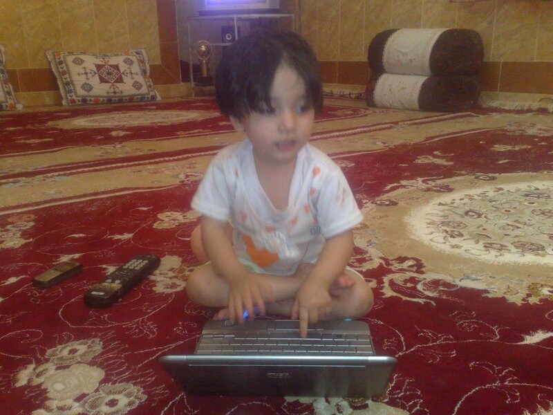 child using laptop on floor